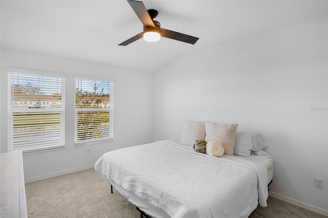 carpeted bedroom featuring lofted ceiling, baseboards, and a ceiling fan