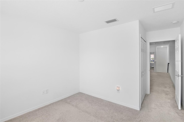 unfurnished room featuring light carpet, visible vents, and baseboards