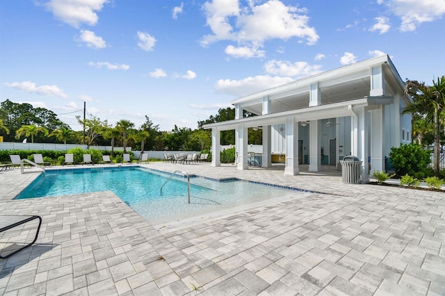 pool with a patio and fence