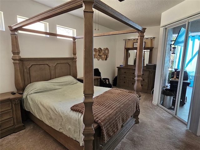 carpeted bedroom featuring a textured ceiling and access to exterior