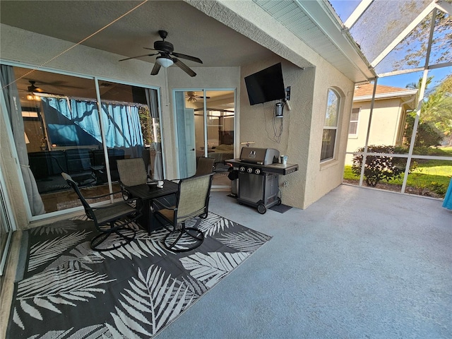 view of patio with glass enclosure, a grill, and a ceiling fan