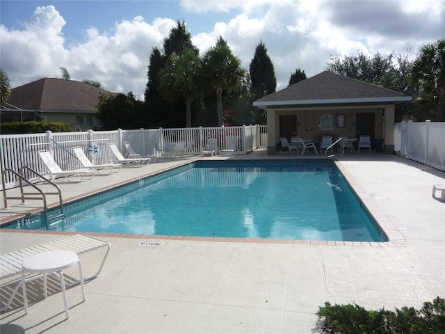 community pool with a patio and fence