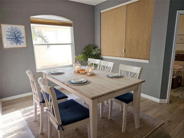 dining area featuring baseboards and light wood-style floors