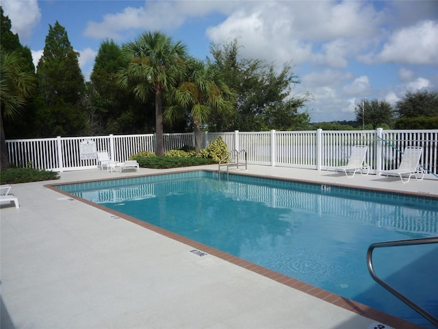 community pool featuring a patio and fence