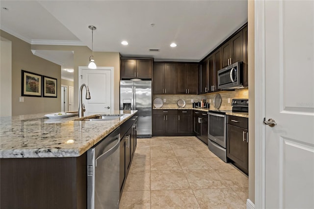 kitchen featuring stainless steel appliances, a sink, dark brown cabinets, backsplash, and pendant lighting