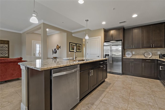 kitchen with appliances with stainless steel finishes, open floor plan, hanging light fixtures, a kitchen island with sink, and a sink