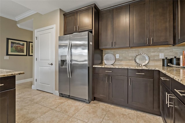 kitchen with tasteful backsplash, ornamental molding, stainless steel refrigerator with ice dispenser, and dark brown cabinets