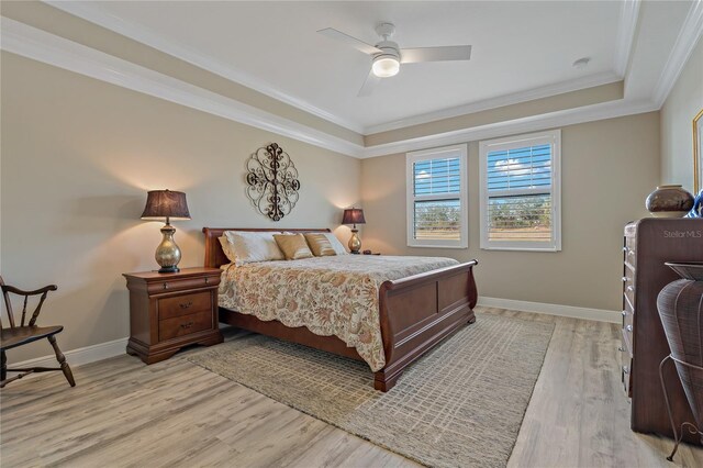 bedroom with light wood finished floors, baseboards, ornamental molding, and a ceiling fan