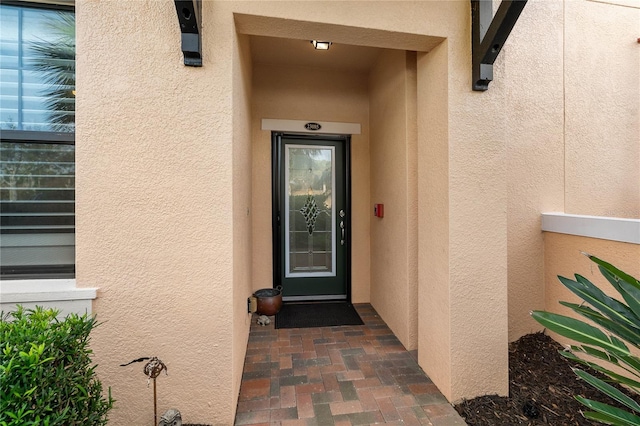 doorway to property featuring stucco siding