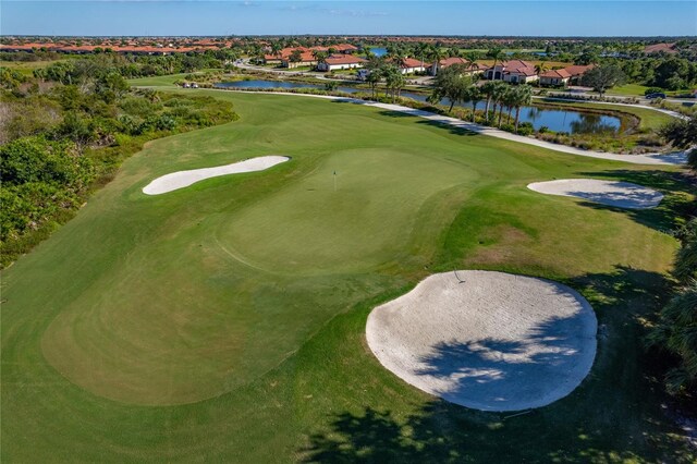 aerial view featuring golf course view, a water view, and a residential view