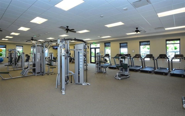 exercise room featuring plenty of natural light, visible vents, a drop ceiling, and a ceiling fan