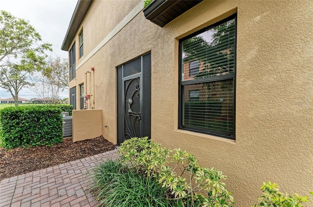 doorway to property featuring stucco siding