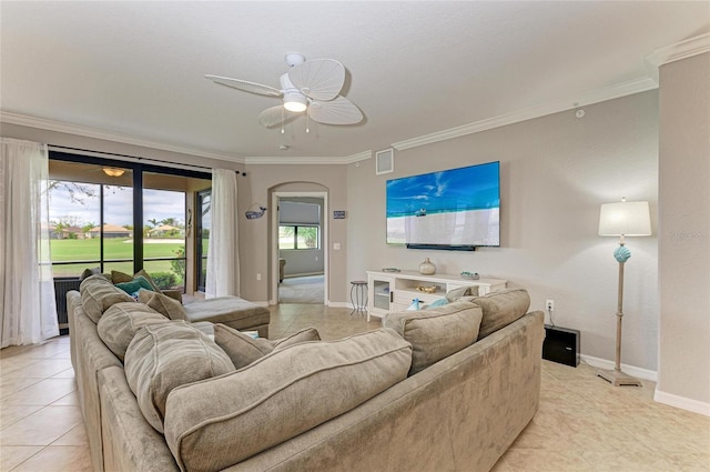 living room featuring arched walkways, visible vents, crown molding, and baseboards