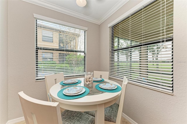 dining space with crown molding, a textured wall, and baseboards