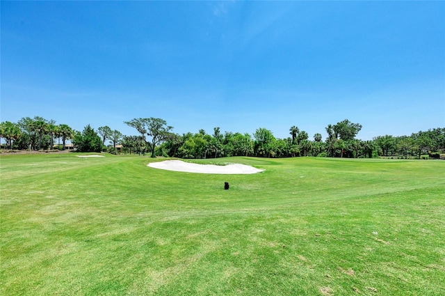 view of property's community with golf course view and a yard