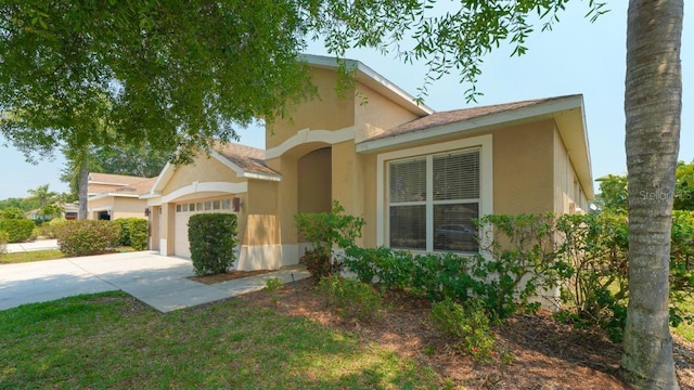 view of home's exterior with a garage, concrete driveway, and stucco siding