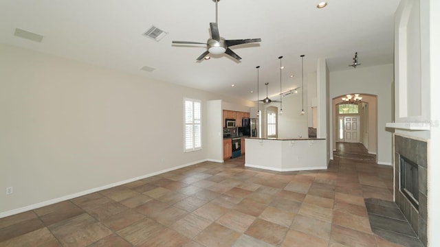 kitchen featuring ceiling fan with notable chandelier, a peninsula, visible vents, vaulted ceiling, and appliances with stainless steel finishes