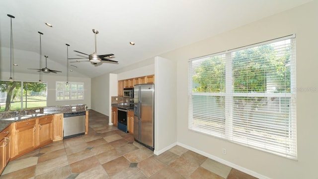 kitchen featuring ceiling fan, stainless steel appliances, a sink, vaulted ceiling, and pendant lighting