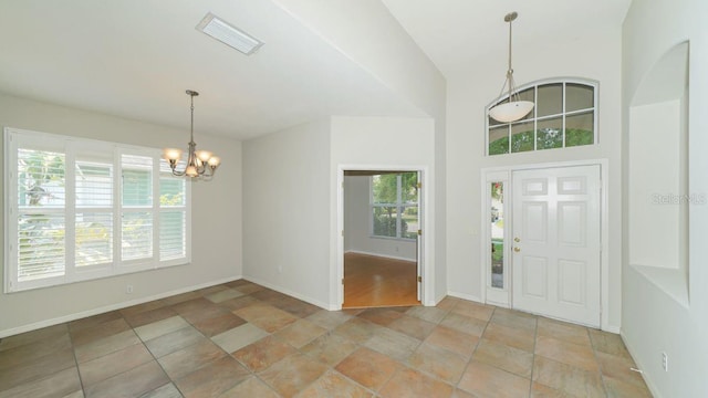 foyer featuring baseboards, visible vents, and a notable chandelier