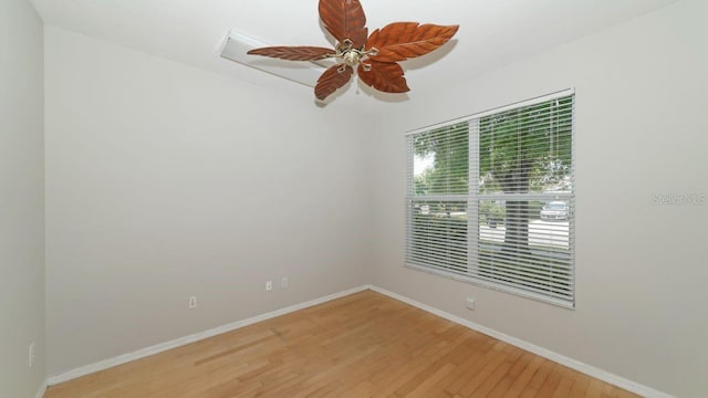 unfurnished room with ceiling fan, wood finished floors, and baseboards