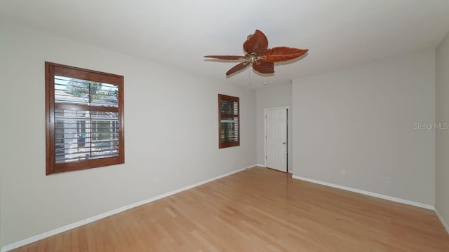 empty room with light wood-style floors, ceiling fan, and baseboards