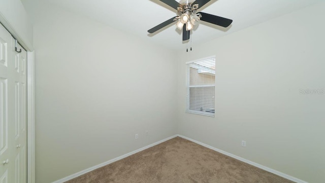 empty room featuring baseboards, a ceiling fan, and light colored carpet