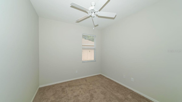 unfurnished room featuring light colored carpet, ceiling fan, and baseboards