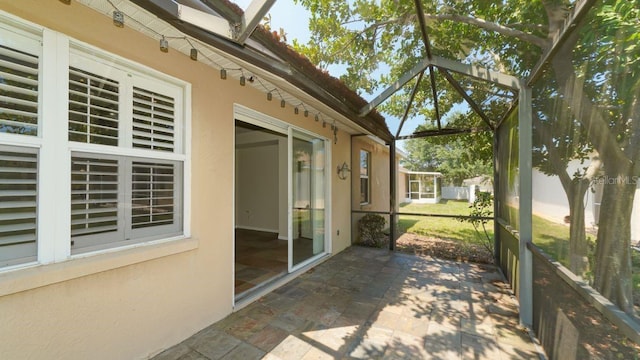 view of patio featuring glass enclosure