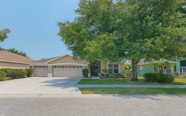 view of front of house featuring a garage, driveway, and stucco siding