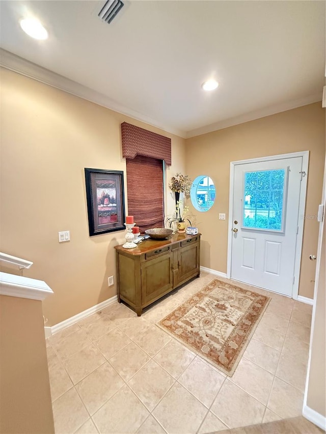 entrance foyer featuring ornamental molding, visible vents, baseboards, and light tile patterned floors