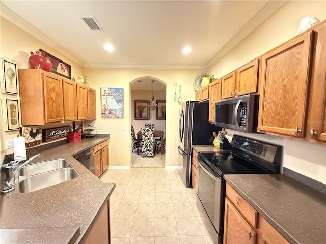 kitchen with appliances with stainless steel finishes, dark countertops, visible vents, and a sink