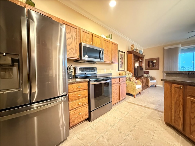 kitchen with light tile patterned floors, appliances with stainless steel finishes, brown cabinets, dark countertops, and crown molding