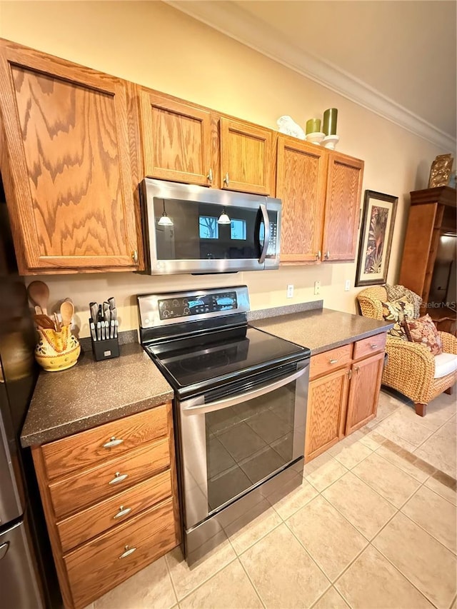 kitchen featuring dark countertops, brown cabinets, stainless steel appliances, and crown molding