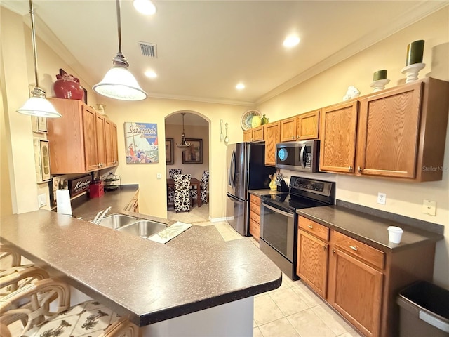 kitchen with decorative light fixtures, stainless steel appliances, dark countertops, visible vents, and a kitchen bar