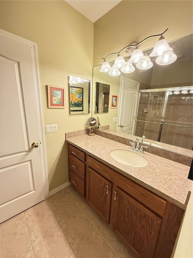 bathroom with baseboards, a shower stall, vanity, and tile patterned floors