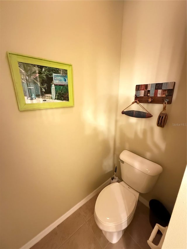 bathroom featuring tile patterned flooring, toilet, and baseboards