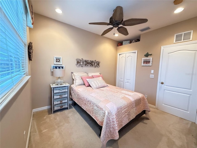 bedroom featuring a closet, visible vents, and light carpet