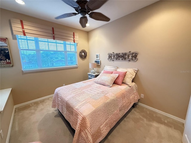 bedroom featuring light carpet, ceiling fan, and baseboards