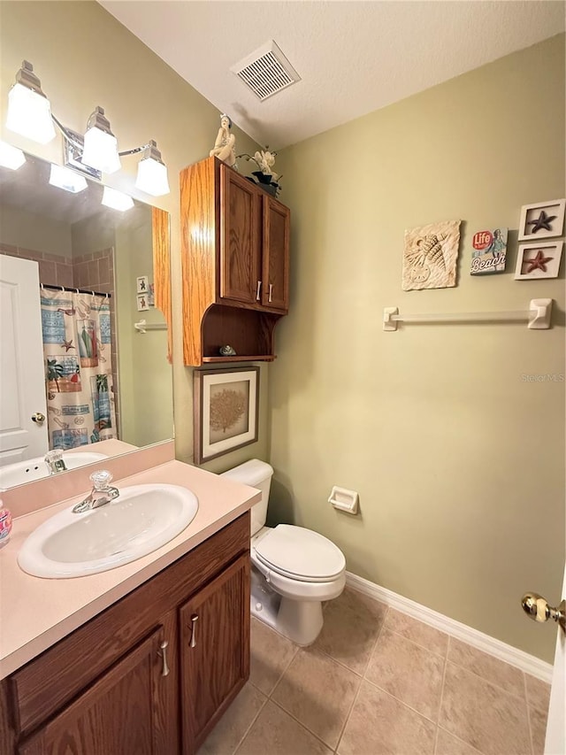 full bathroom with toilet, vanity, baseboards, visible vents, and tile patterned floors