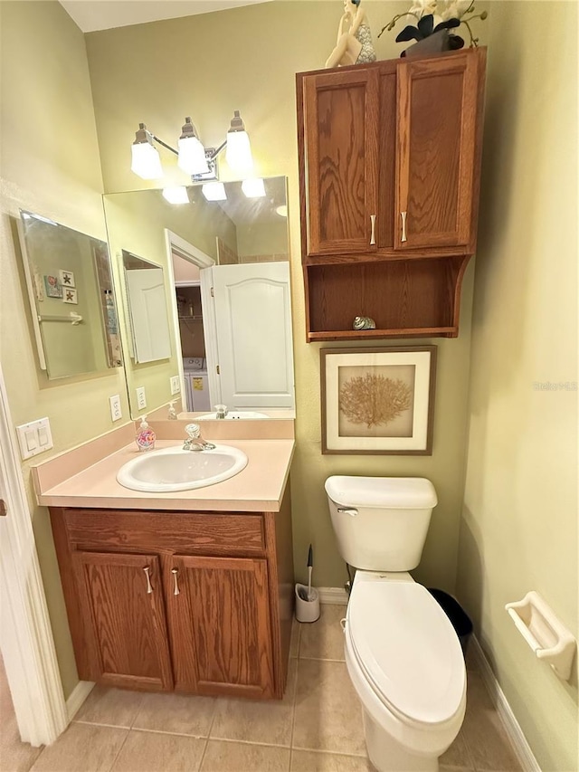 bathroom with baseboards, vanity, toilet, and tile patterned floors