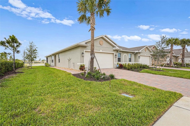 view of front of home with a front yard, decorative driveway, an attached garage, and stucco siding