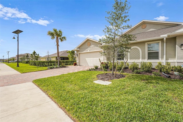 view of front of property with a garage, a front lawn, decorative driveway, and stucco siding