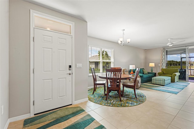 dining room with light tile patterned floors, ceiling fan with notable chandelier, a wealth of natural light, and baseboards