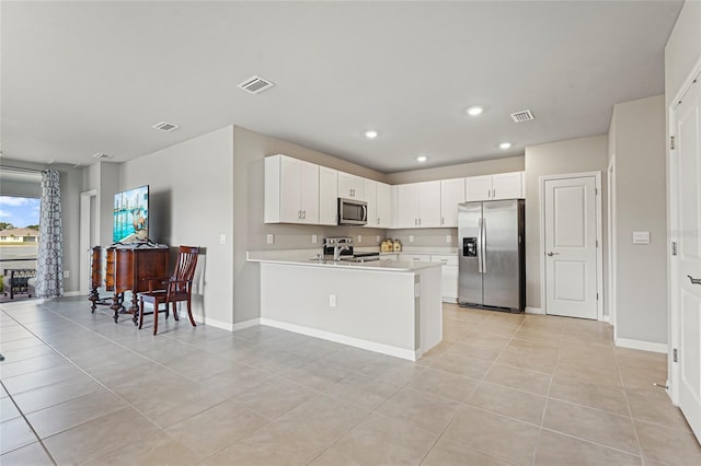 kitchen featuring a peninsula, visible vents, appliances with stainless steel finishes, and light countertops