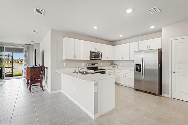 kitchen with stainless steel appliances, light countertops, visible vents, and a sink