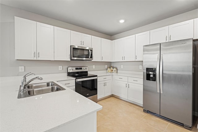 kitchen with light tile patterned floors, stainless steel appliances, a sink, and white cabinetry