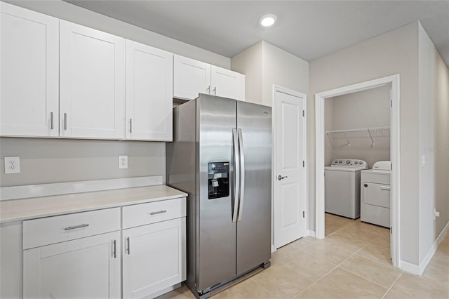 kitchen featuring light countertops, white cabinetry, light tile patterned flooring, separate washer and dryer, and stainless steel fridge