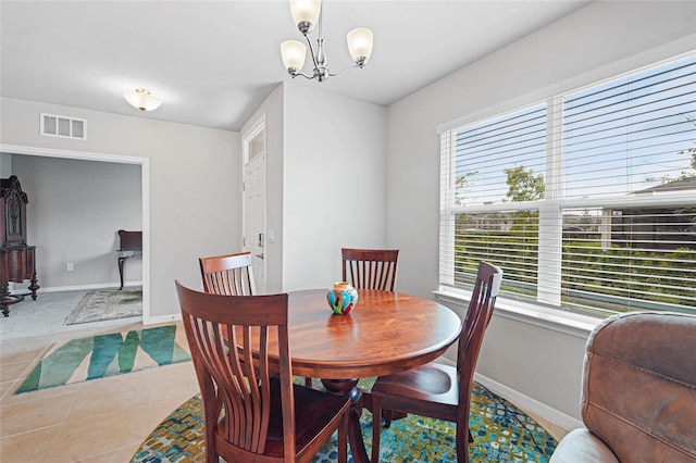 tiled dining space with visible vents, baseboards, and an inviting chandelier