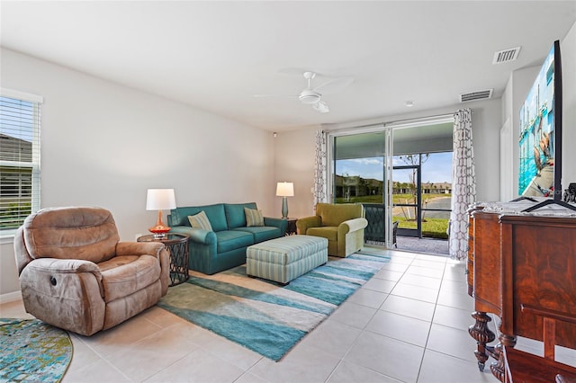 living area with light tile patterned floors, ceiling fan, and visible vents