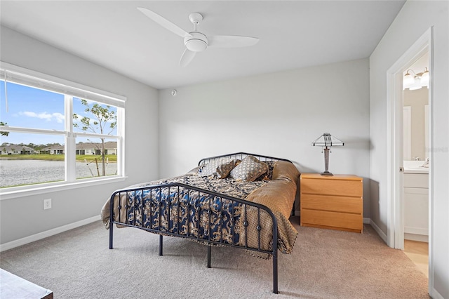 bedroom with ensuite bathroom, carpet floors, a ceiling fan, and baseboards